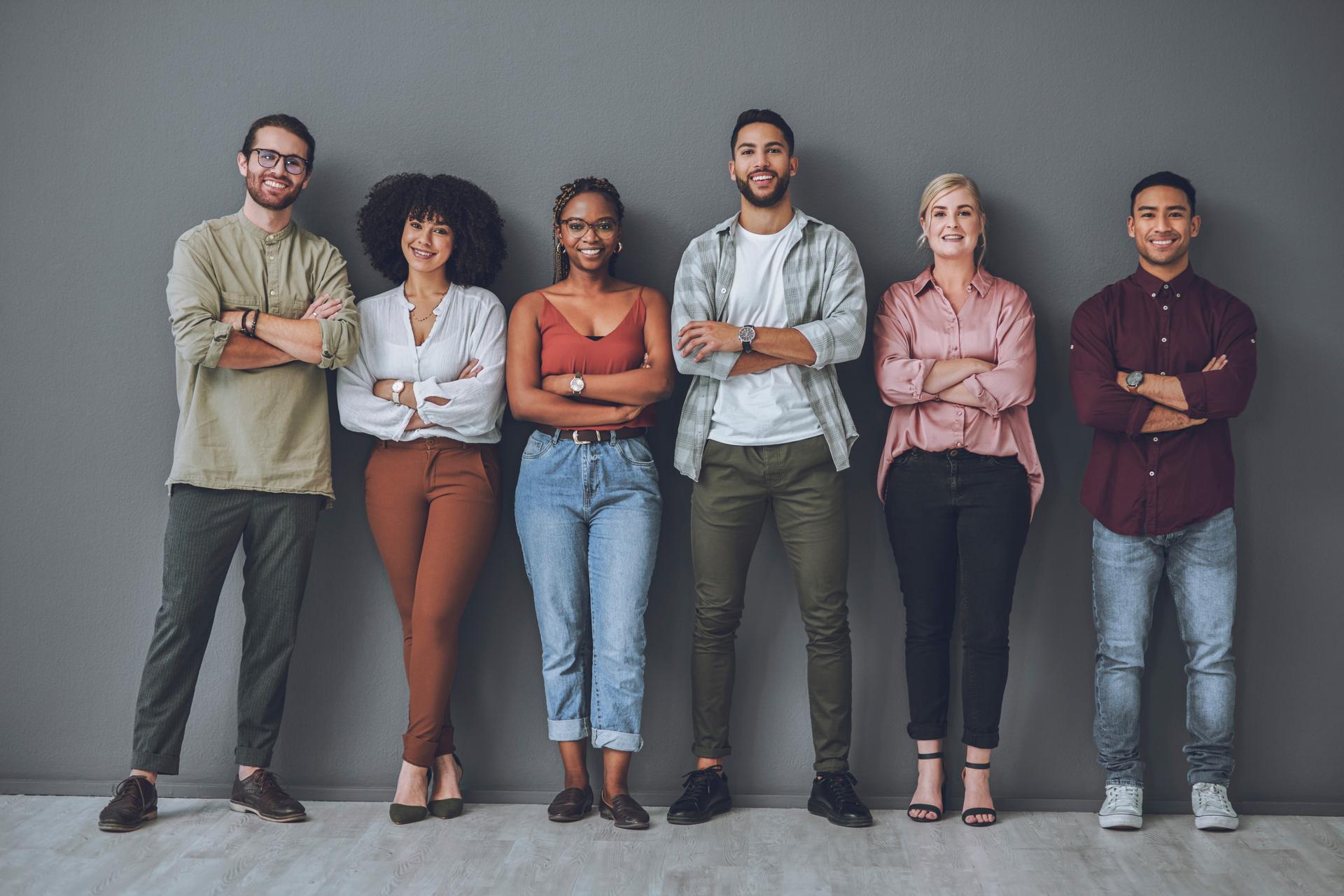 Studio portrait of a diverse group of people standing together against a grey background