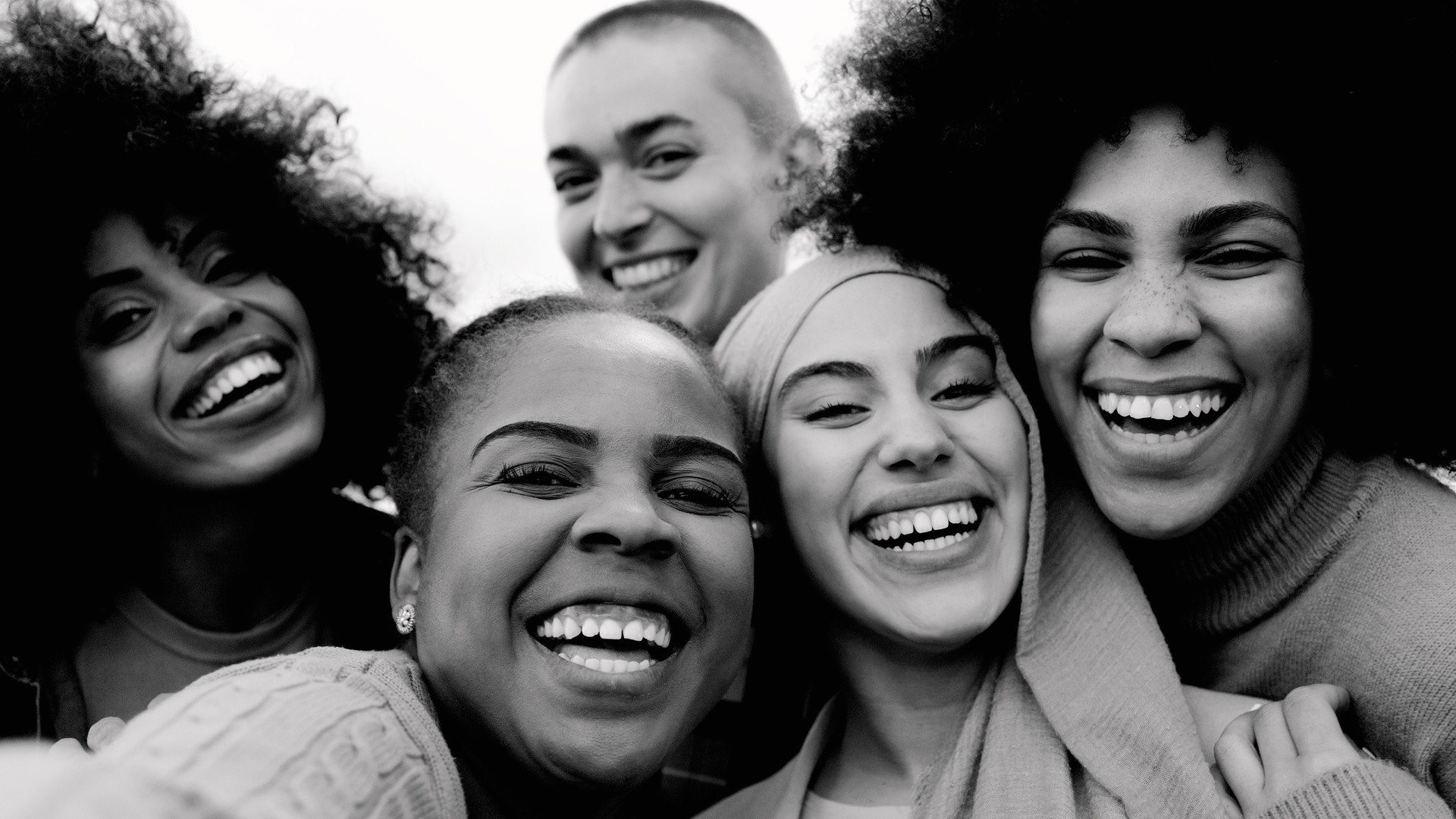 Happy group of multiracial women having fun outdoors - Real people from different ethnicity celebrating outdoors - Lifestyle and youth culture concept - Black and white editing